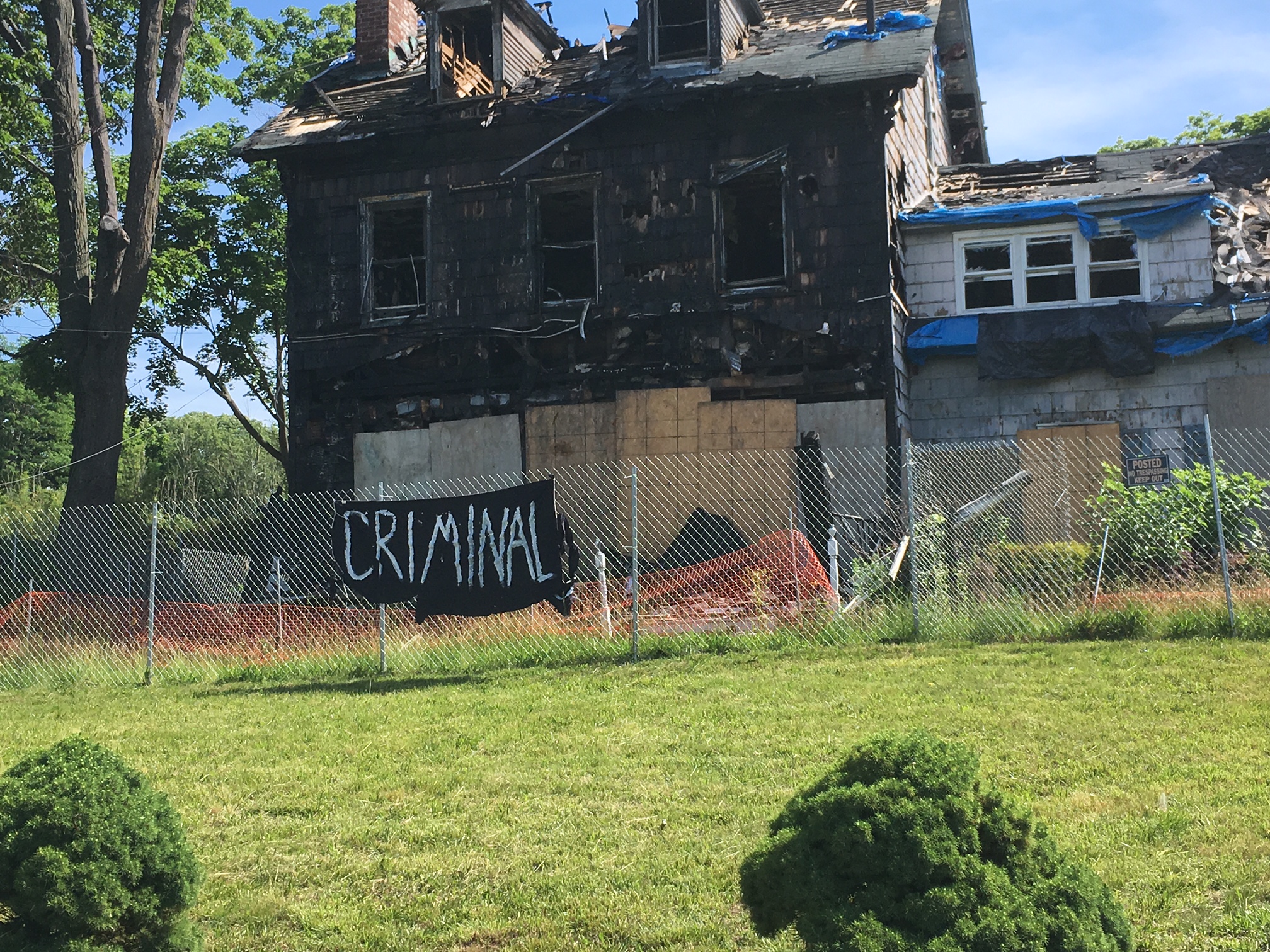 Village removes signs that say ‘criminal’ from in front of the Baxter House
