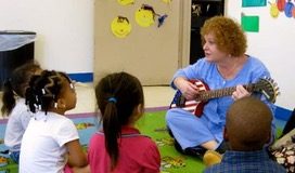 Marilyn Hoffman, well known for her songs and guitar, teaches a group of young students through song. (Photo courtesy of Barbara Masry)