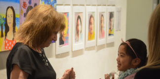 Ellen Schiff, the head of school at the Gold Coast Arts Center, greets one of her students at the opening reception of the Festival of the Arts gallery. (Photo by Janelle Clausen)