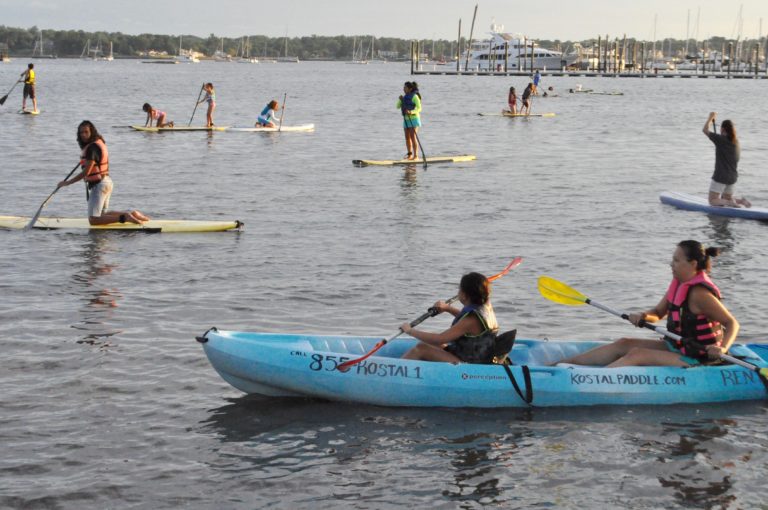 Teenagers paddle out to clean the bay