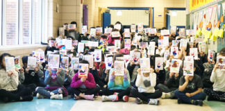 Students hold up the cards they created for troops serving overseas. (Photo courtesy of the Great Neck Public Schools)