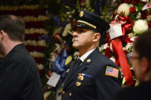 An Alert Fire Company member stands stationed in front of Ray Plakstis' open casket on Thursday night. (Photo by Janelle Clausen)