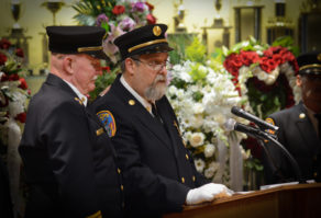 Thomas McDonough, Ray Plakstis' brother and former chief of the Port Washington Fire Department, comforts Michael Berry as he speaks about Plakstis. (Photo by Janelle Clausen)