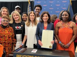 Linda Schulman (center-right) is pictured with Governor Kathy Hochul (center left) after Hochul signed a ten-bill package on gun safety.